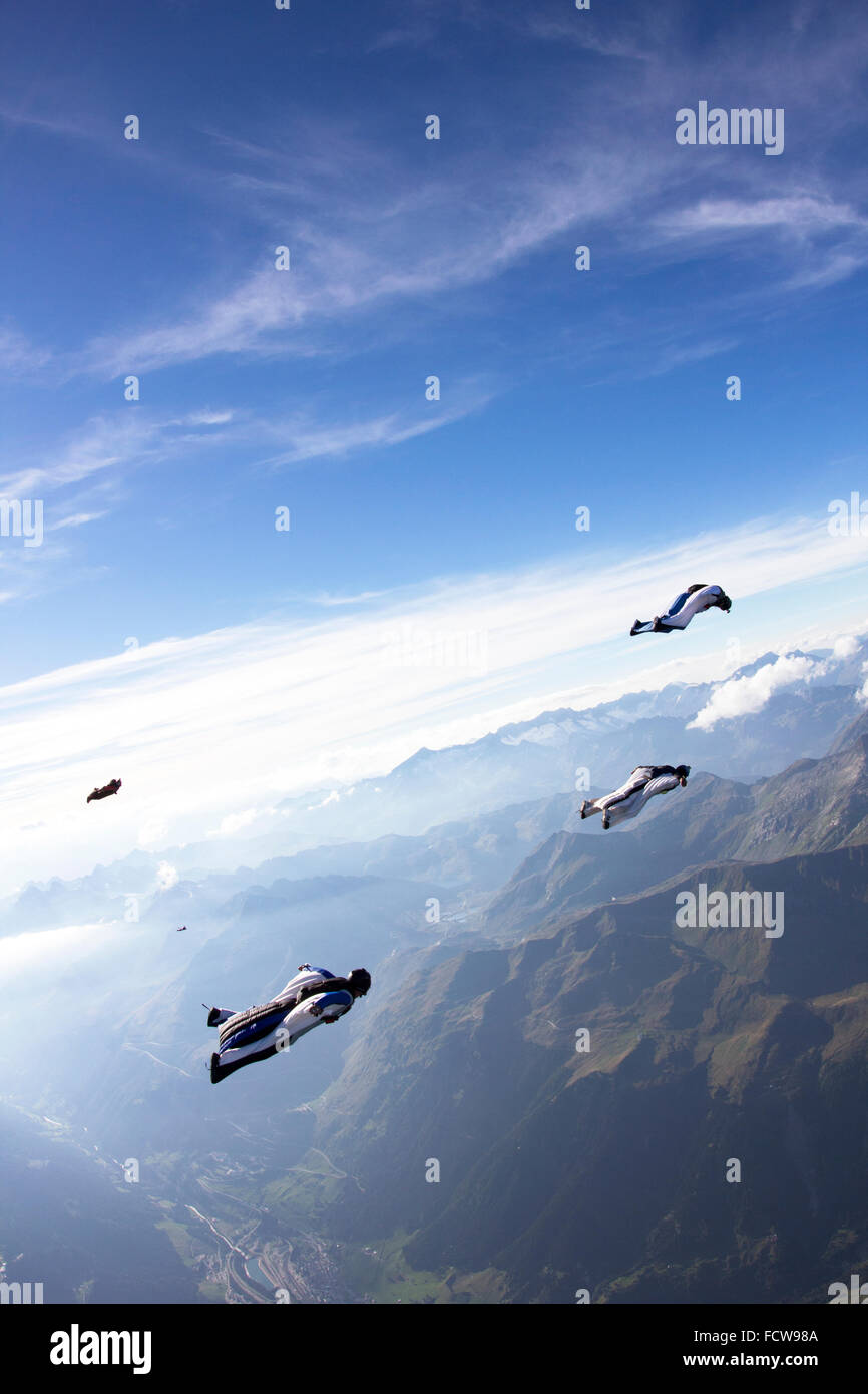 Wingsuit Piloten Fliegen In Einer Gruppe Zusammen Der Fuhrer Im Weissen Anzug Ist Fliegen Weiter Und Leiten Sie Uber Die Berge Stockfotografie Alamy