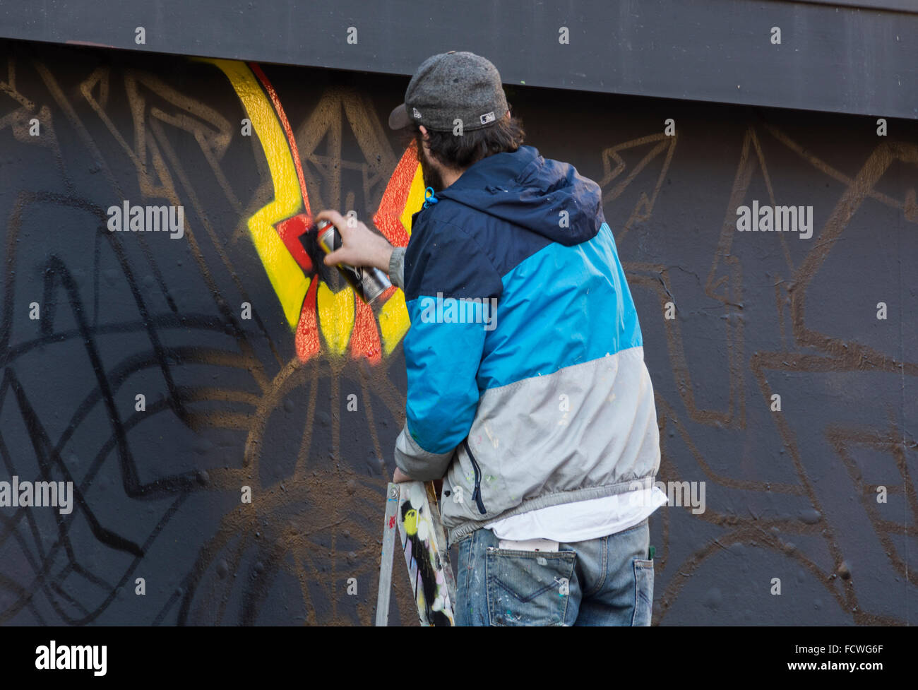 Streetart-Künstler bei der Arbeit an einem neuen Stück im Zentrum von Bristol, UK. Stockfoto