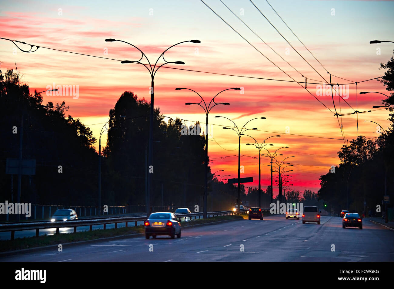 Auto auf einer Autobahn mit majestätischen Sonnenuntergang Himmel Stockfoto