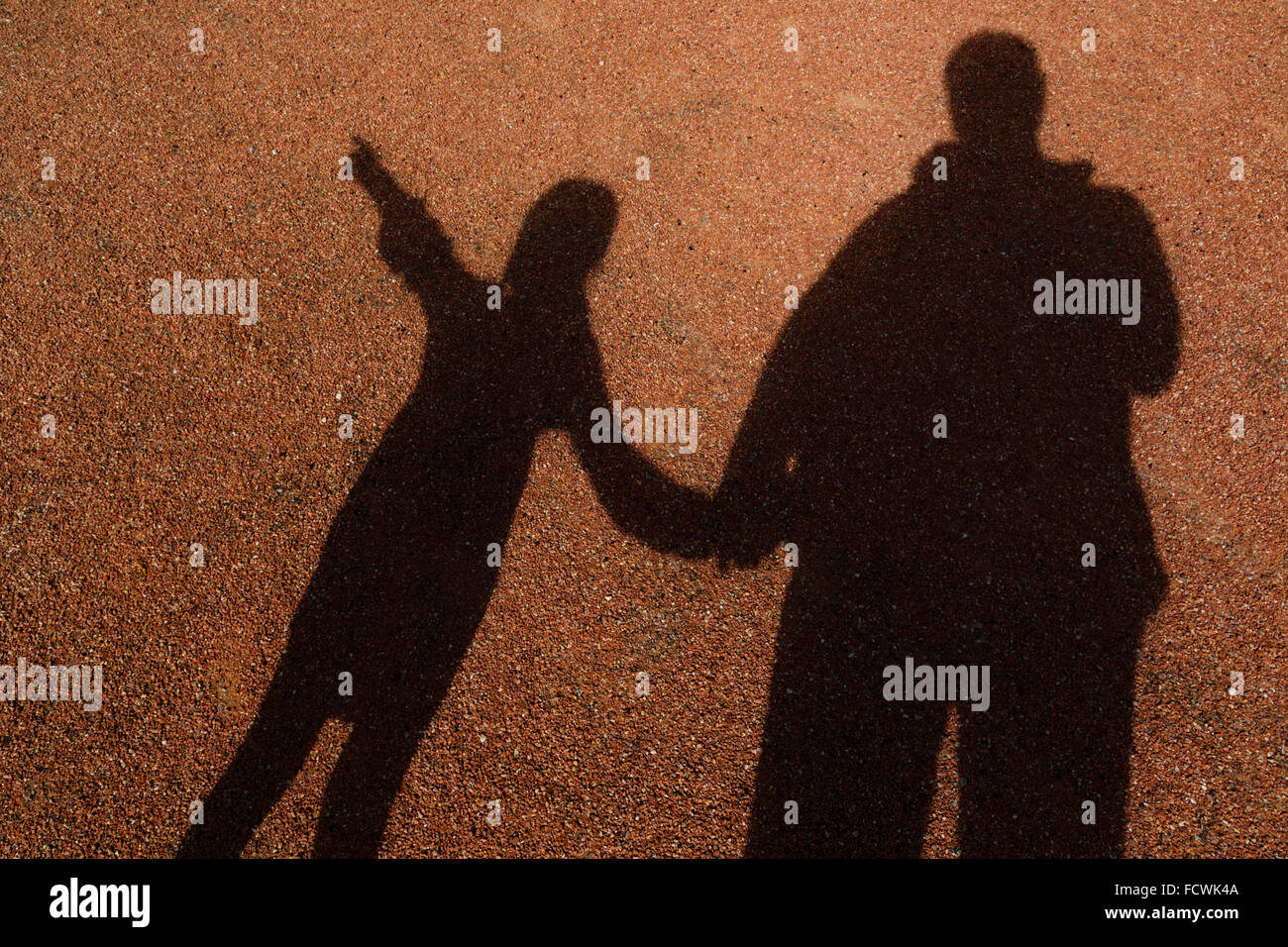 Schatten der Erwachsenen und jungen Mädchen Hand in Hand. Kleines Mädchen zeigt, Stockfoto