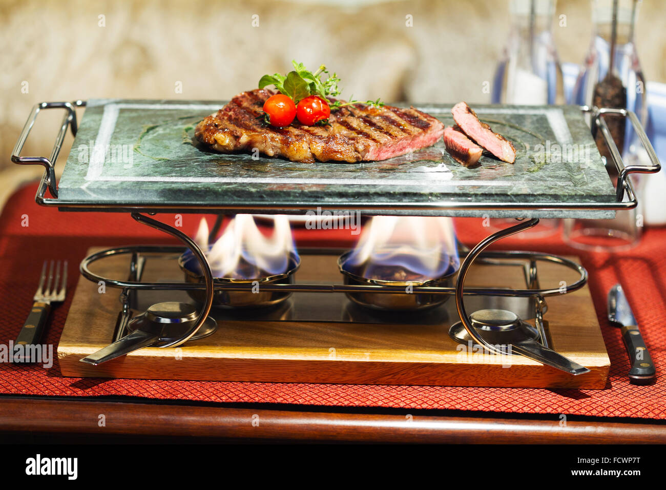 Zubereitung von gegrilltem Fleisch mit Tomaten auf einem Marmor Tablett Stockfoto