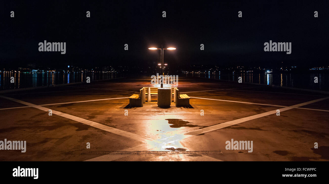 Nachts auf einem einsamen Pier in Halifax, Nova Scotia.  Lichter der Stadt Halifax über den Hafen. Stockfoto