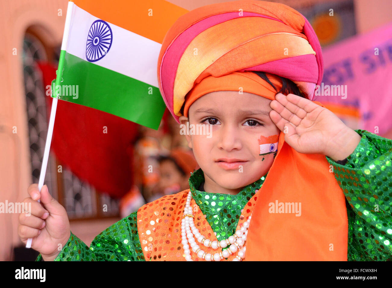 Rajasthan, Indien. 25. Januar 2016. Indische erste Schritt Schülerinnen und Schüler malen die Trikolore der indischen Flagge auf ihrem Gesicht und erhöhen die Nationalflagge am Vorabend der Republik Day Feierlichkeiten in Rajasthan, Indien. © Shaukat Ahmed/Pacific Press/Alamy Live-Nachrichten Stockfoto