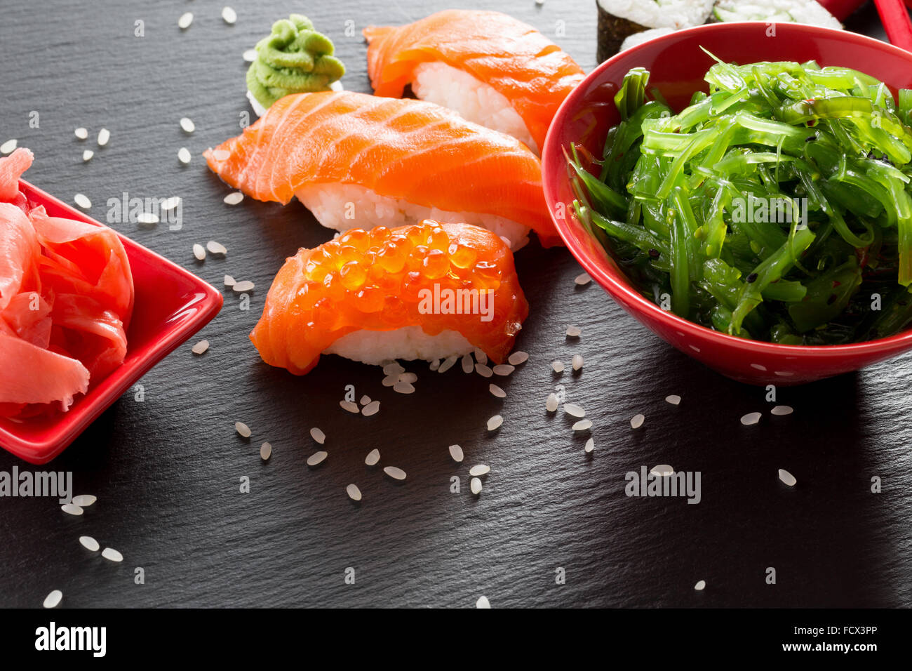 Sushi und grünem Seetang Salat auf einem Schiefer Tisch. Stockfoto