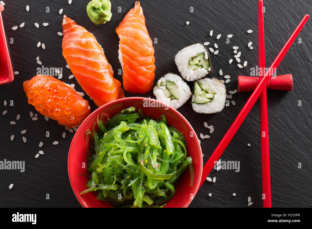 Sushi und grünem Seetang Salat auf einem Schiefer Tisch. Stockfoto