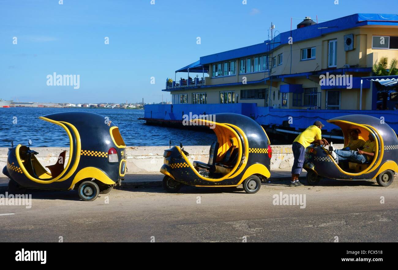 Drei Cocotaxis und ihre Fahrer im Hafen von Havanna im 26. Dezember 2013. Stockfoto