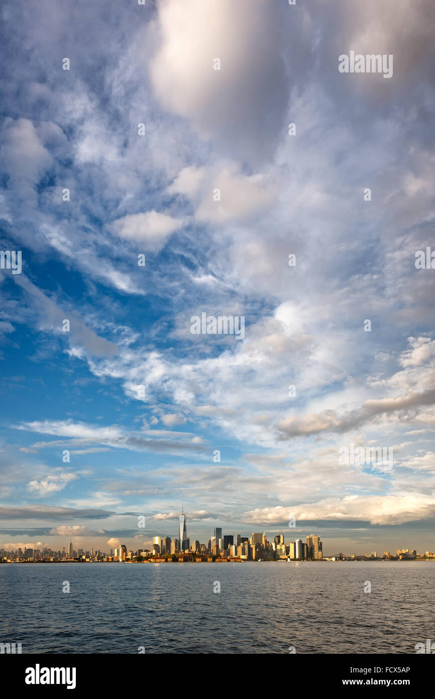 Licht nach dem Sturm über Lower Manhattan Financial District Wolkenkratzern mit Ellis Island, New York City Stockfoto