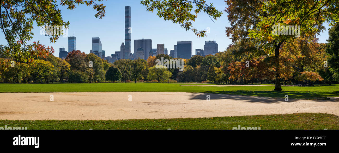Am Nachmittag Panoramablick über Central Park große Liegewiese mit Herbst Laub und Manhattan Midtown Wolkenkratzer. Herbst in New York City Stockfoto