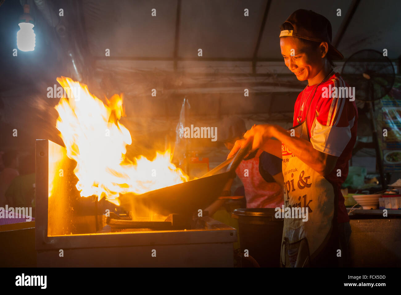 Ein Koch verwendet eine Wok-Pfanne Kochen Nudeln und Flammen um seinen Pfanne hat, den Markt, Kota Kinabalu, Malaysia Borneo Stockfoto