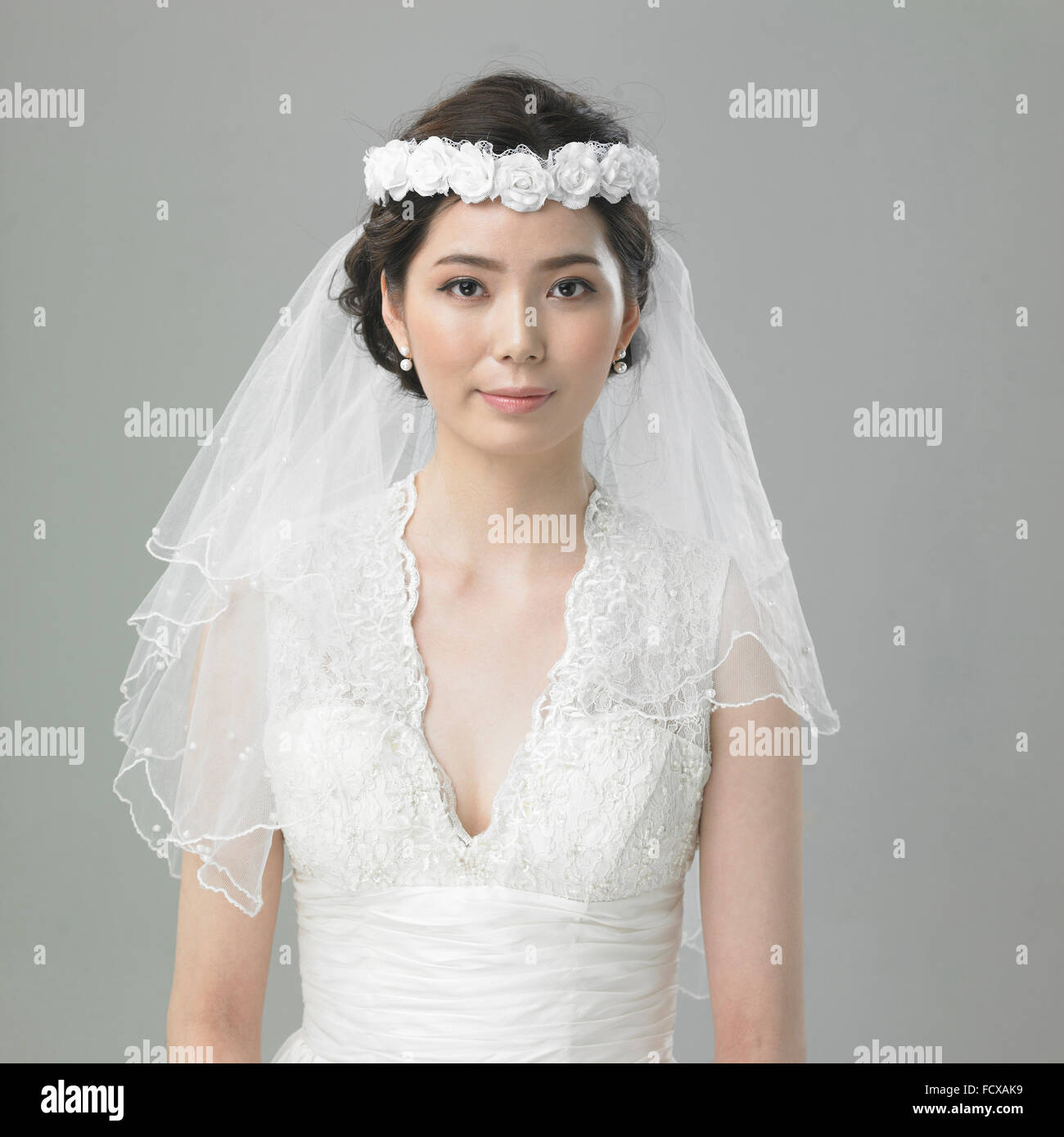 Braut in Blume Krone und Spitze Schleier starrte nach vorne Stockfoto