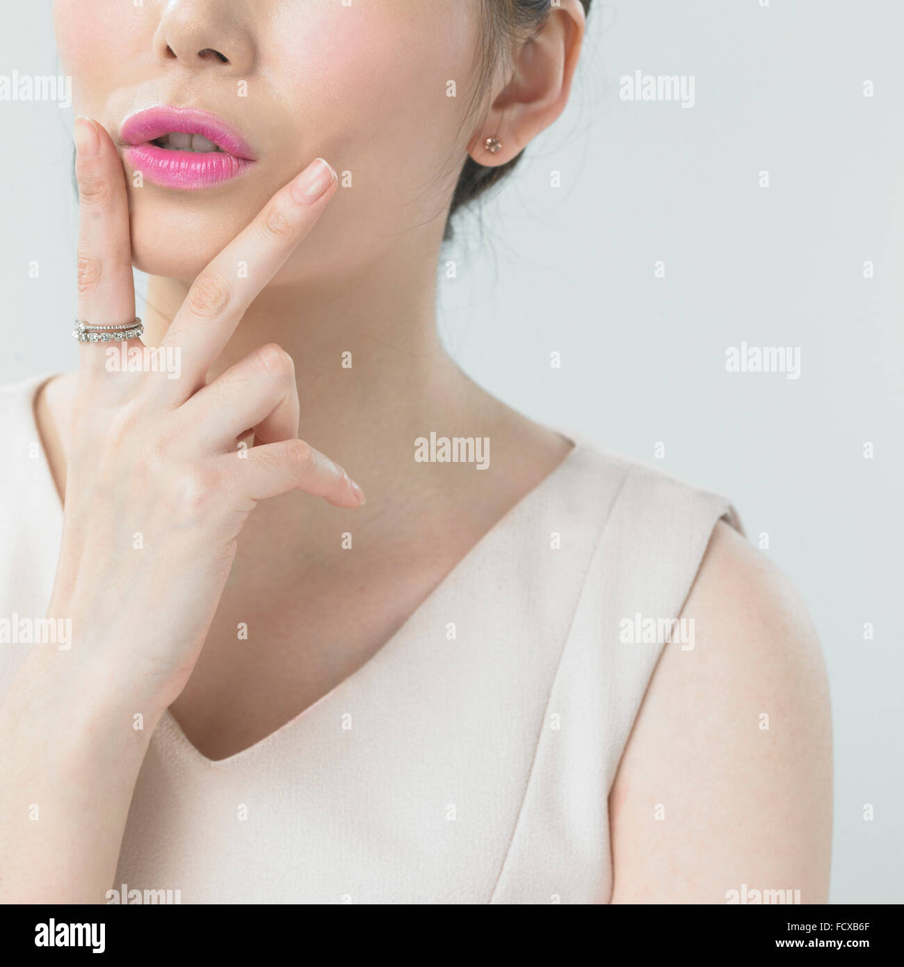 Frau mit rosa Lippen Make-up setzen ihre Finger Aroung Mund V Zeichen Stockfoto