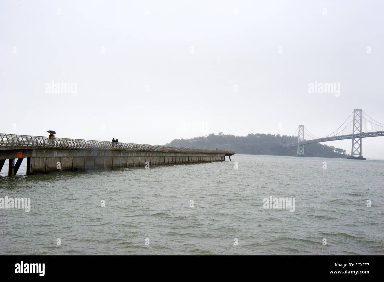Blick auf die Bay Bridge vom Wharf in San Francisco an regnerischen Tag Stockfoto