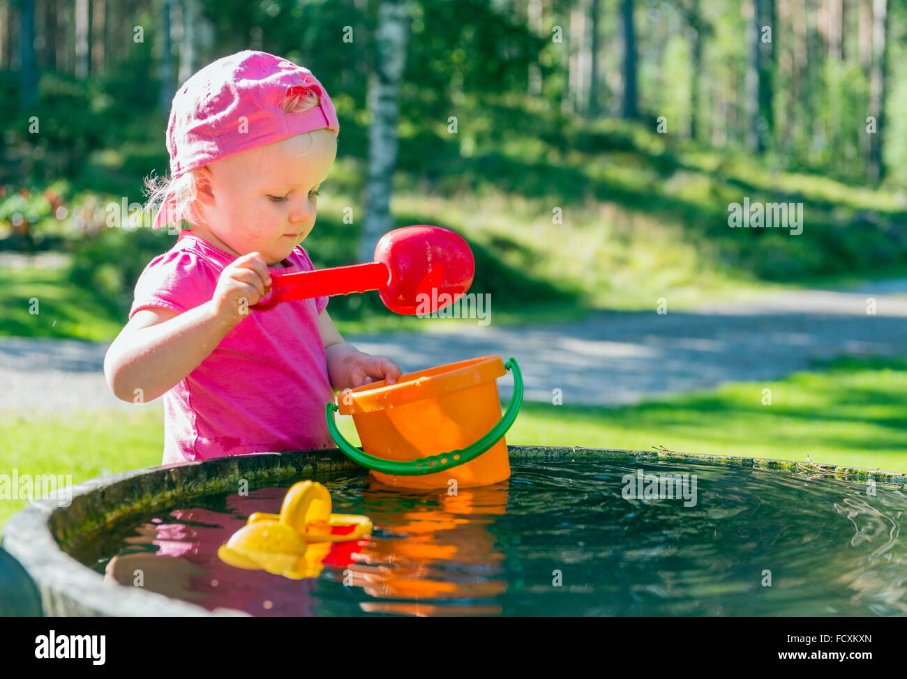 Junges Mädchen mit Wasser spielen Stockfoto