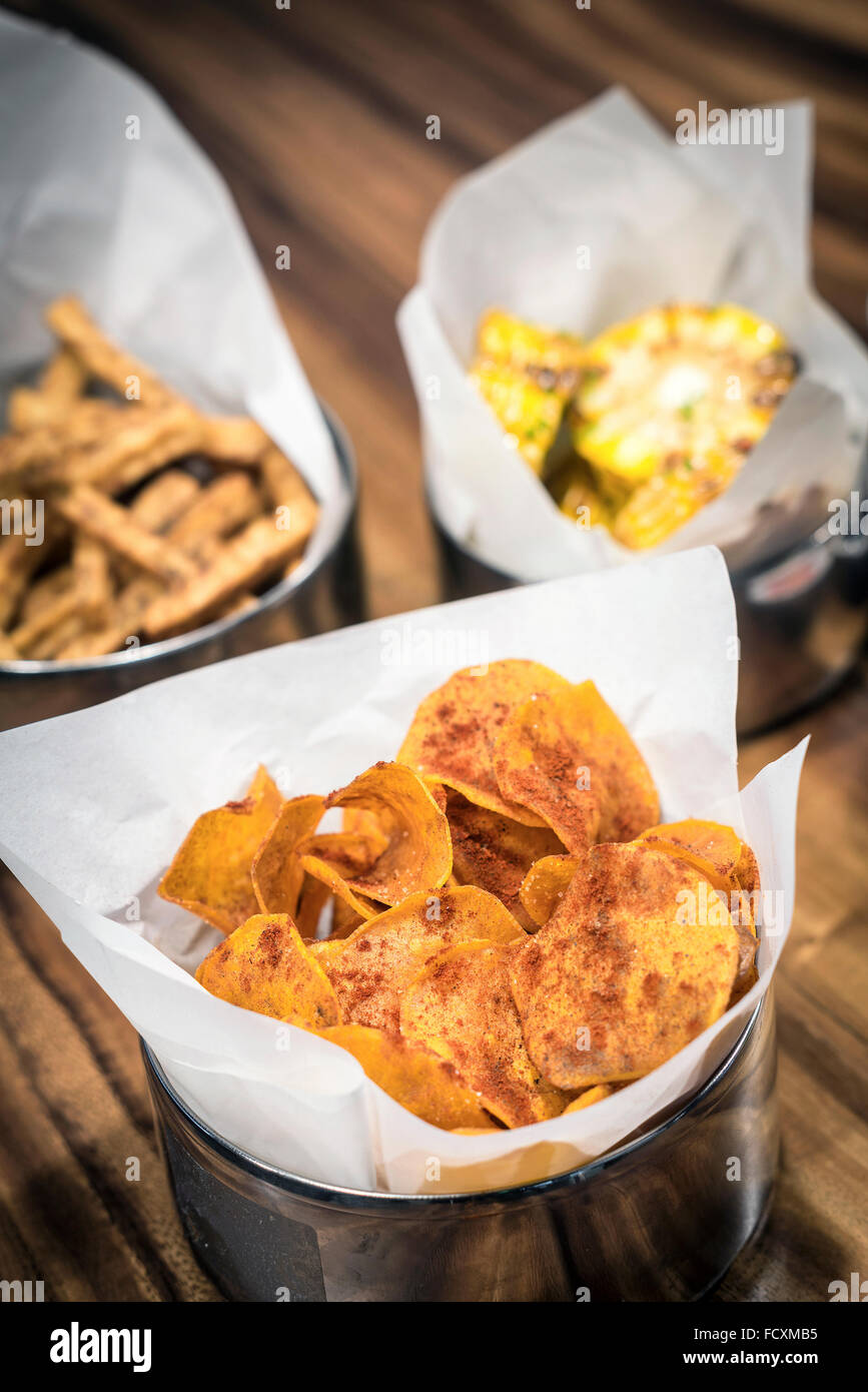 rustikale Kartoffel-Chips und anderen einfachen Snack Essen auf Tisch Stockfoto