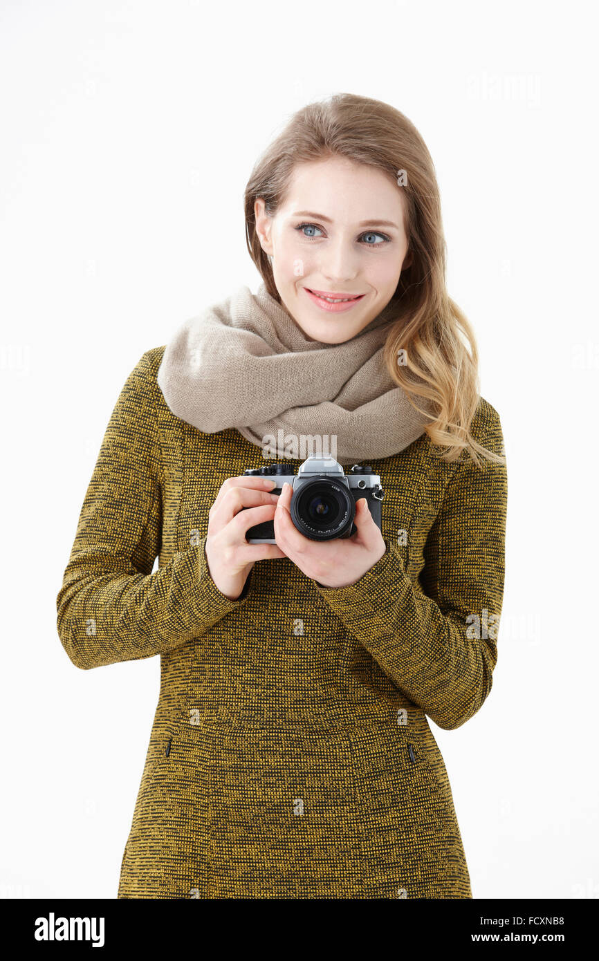 Porträt der jungen lächelnde Frau Wearig einen Schal, eine Kamera zu halten Stockfoto