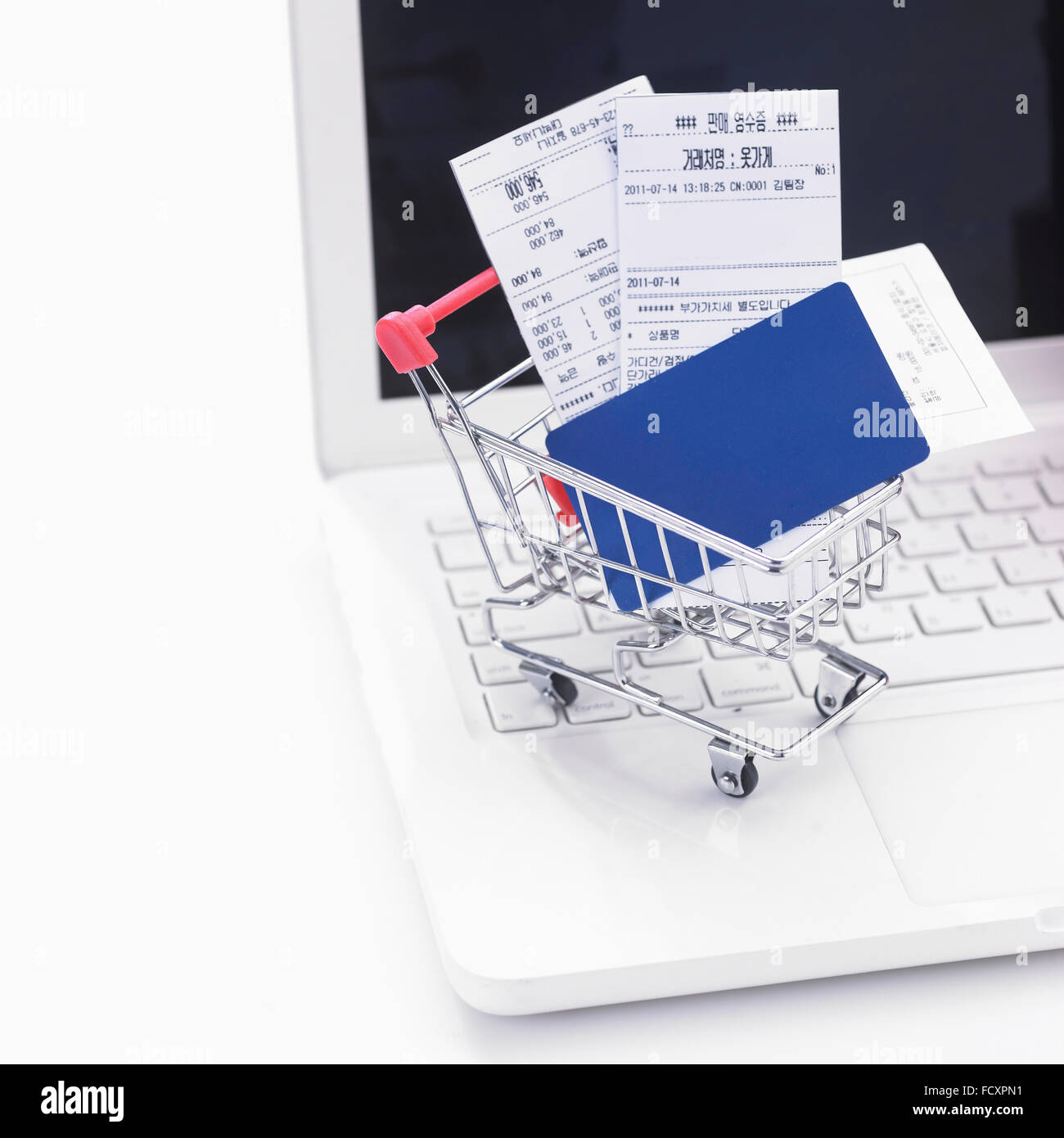 Kreditkarte und Belege in einen Einkaufswagen mit Notebook-computer Stockfoto