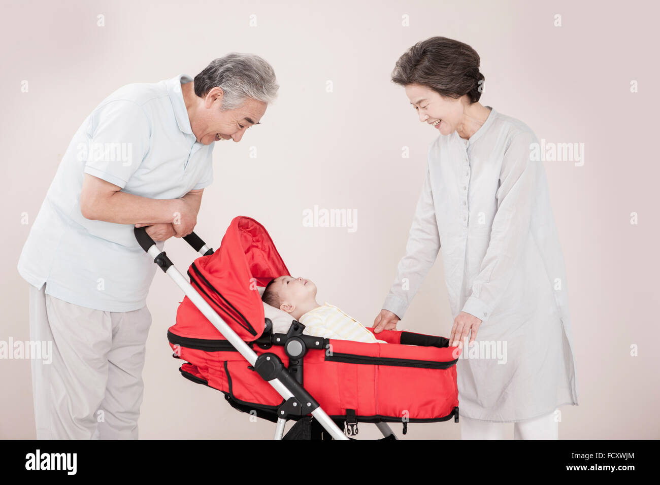 Liebevolle Großeltern kümmert sich um die Enkel im Kinderwagen Stockfoto