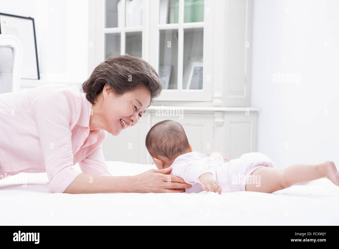 Liebevolle Großmutter spielen mit einem Baby Enkelkind Stockfoto