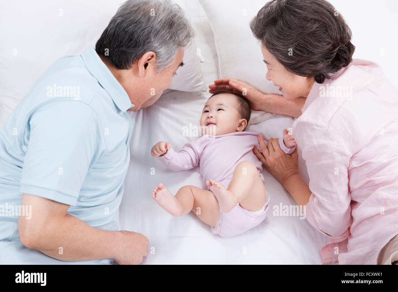 Liebevolle Großeltern spielen mit Baby Enkelkind Stockfoto