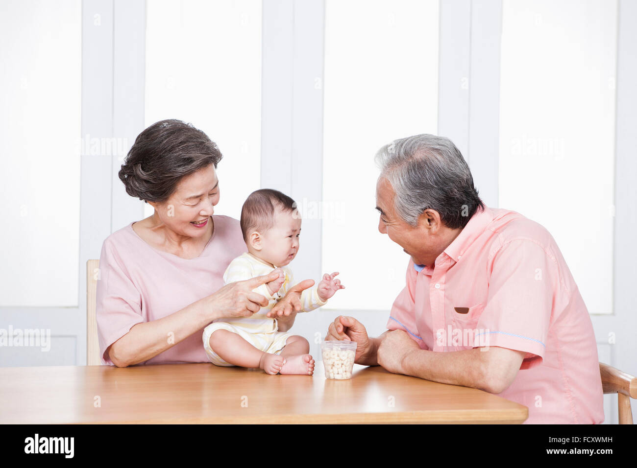Porträt der liebevollen Großeltern mit ihrem Enkelkind Baby spielen Stockfoto