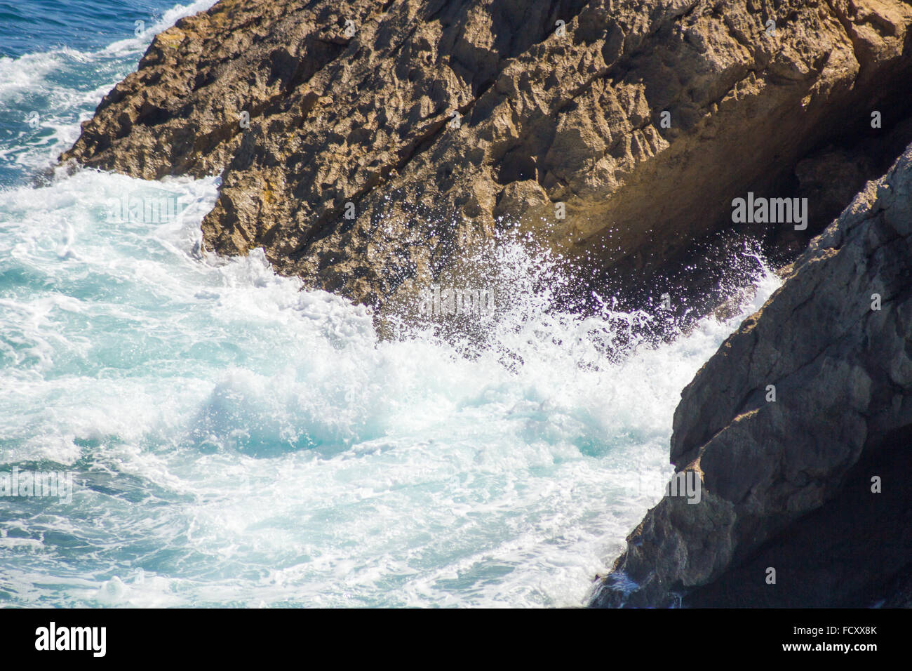 Ozeanwellen an den Felsen mit weißer Schaum Stockfoto