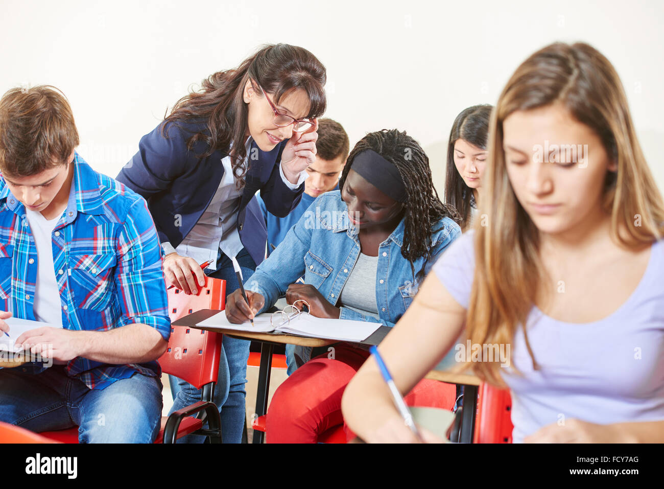 Lehrer steuert ihr Schüler Übung im Unterricht in der Schule Stockfoto