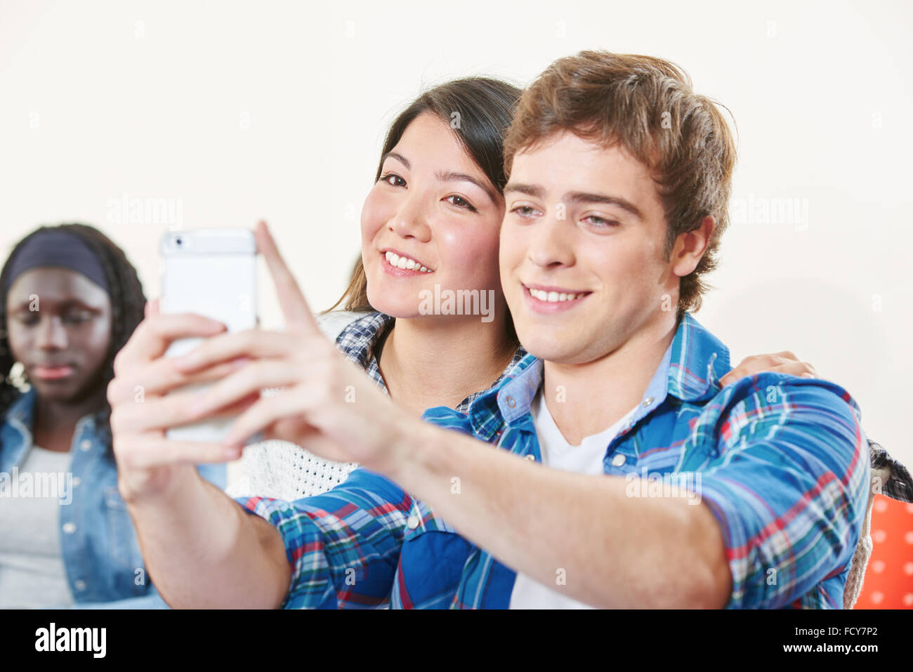 Jungen und Mädchen nehmen ein Selbstporträt in der Klasse mit Ther-Telefon Stockfoto