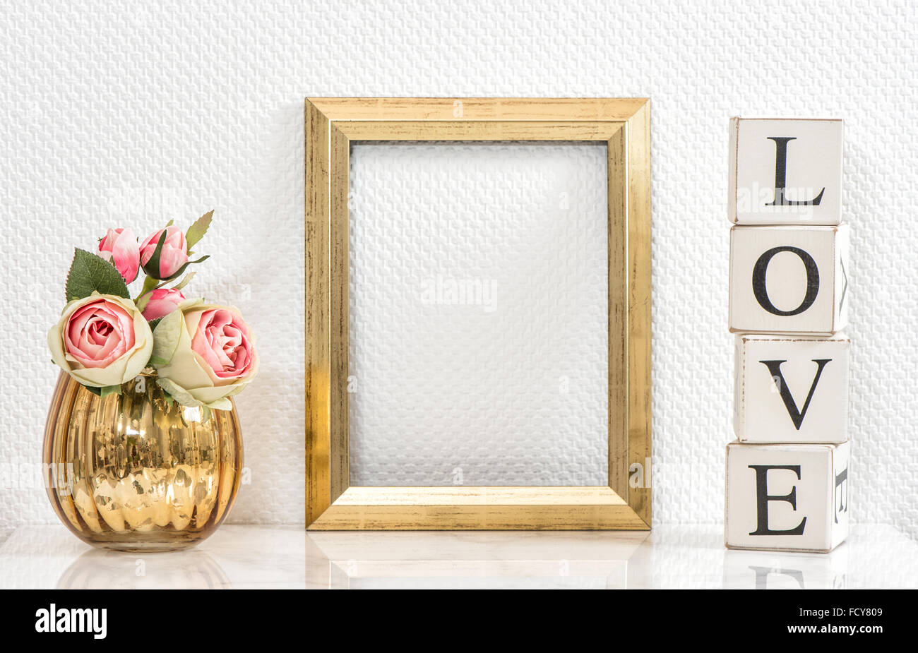 Bilderrahmen und rosa Rosen. Valentinstag-Konzept. Mock-up mit Goldrahmen und Blumen mit Platz für Ihr Bild oder text Stockfoto