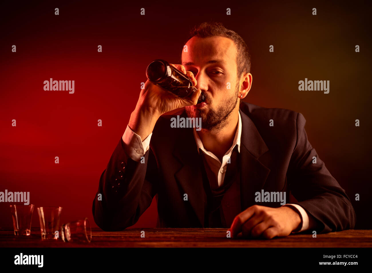 Betrunken Geschäftsmann in einer Kneipe ein Bier trinken Stockfoto