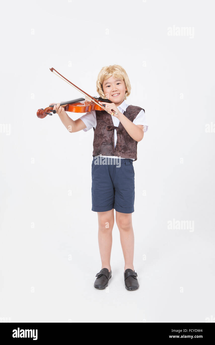 Junge im Stil klassischer Musiker stehen und Violine spielen Stockfoto