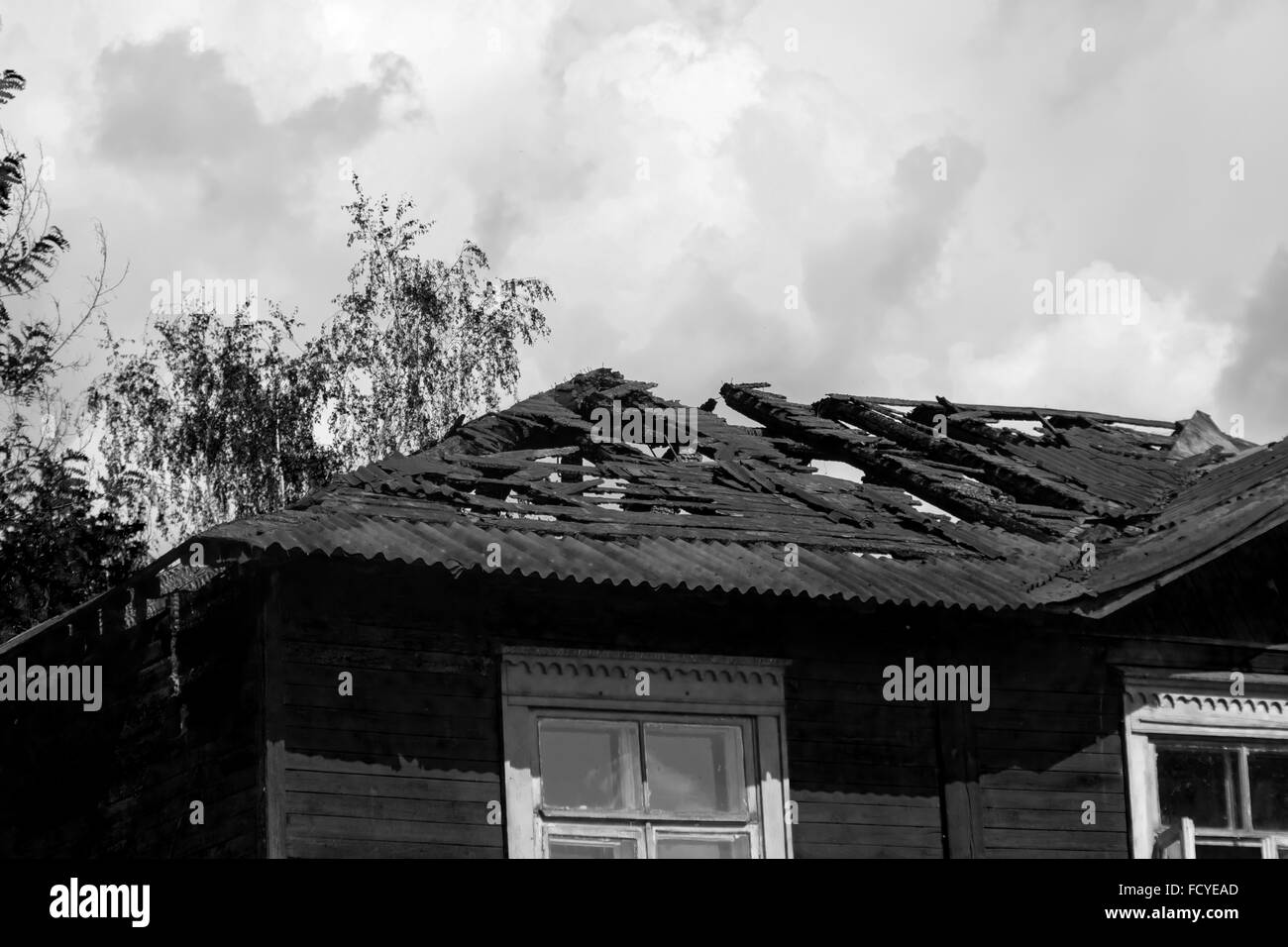 Verbrannte Dach des Hauses am Sommertag in schwarz / weiß Stockfoto