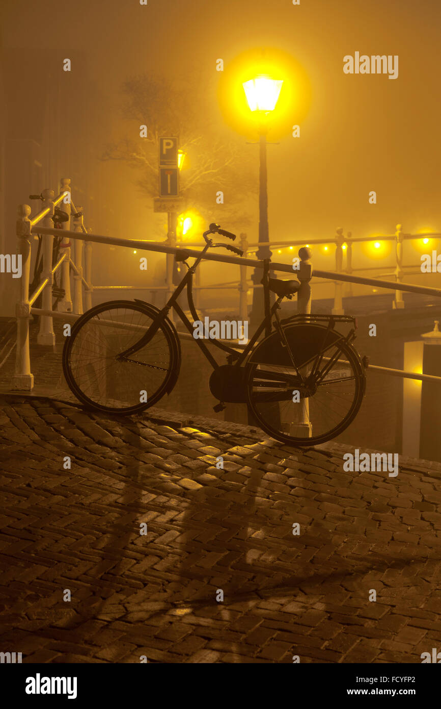 Fahrrad im Nebel auf einer Brücke in Leiden, Niederlande Stockfoto