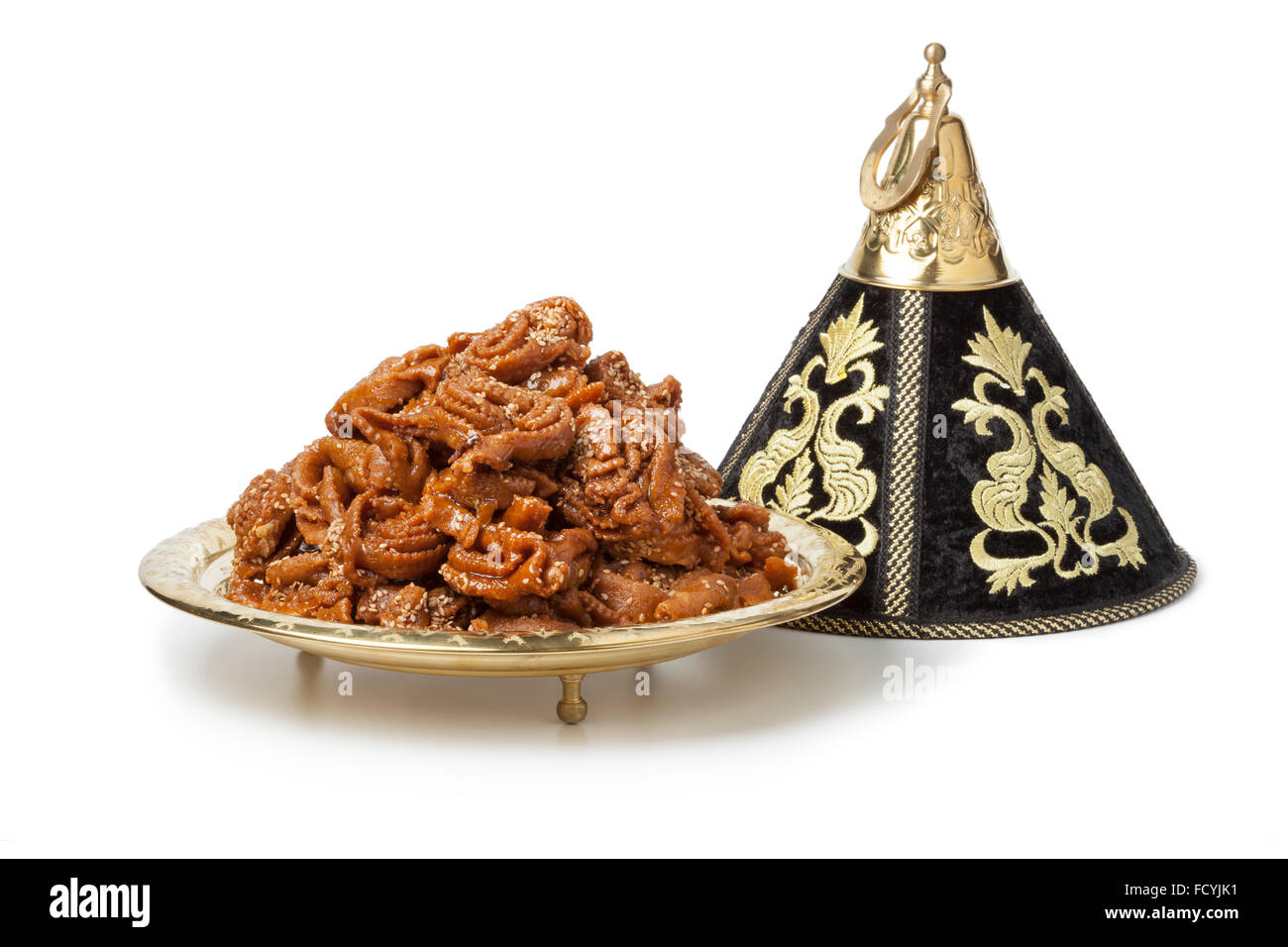 Dekoration-Tajine mit frisch gebackenen Chebakia für Ramadan auf weißem Hintergrund Stockfoto