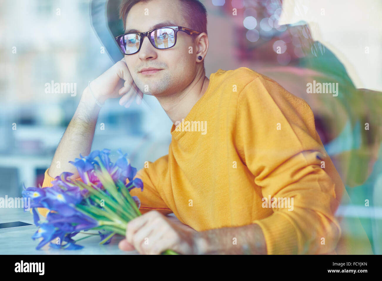 Romantischer junger Mann mit blauen Schwertlilien Stockfoto