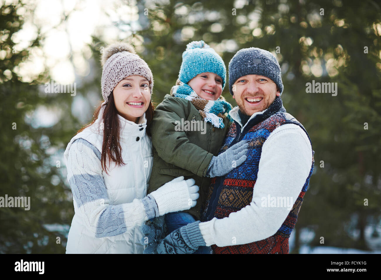 Fröhliche Familie in Winterbekleidung Blick in die Kamera mit einem Lächeln Stockfoto