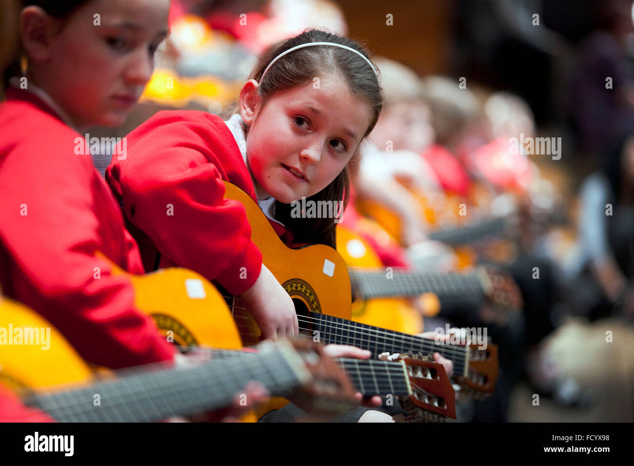 Grundschüler nehmen Teil in einem Gitarren-Konzert in der Bridgewater Hall Manchester Stockfoto