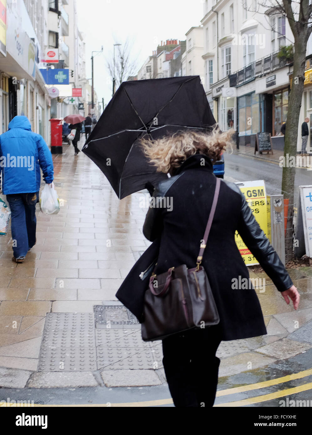 Brighton, UK. 26. Januar 2016. Eine Frau kämpft mit ihrem Schirm in Brighton heute als der Sturm Wetter welche verursacht Schneechaos in den USA kommt in Großbritannien heute bringen, Stürme und Regen Credit: Simon Dack/Alamy Live News Stockfoto