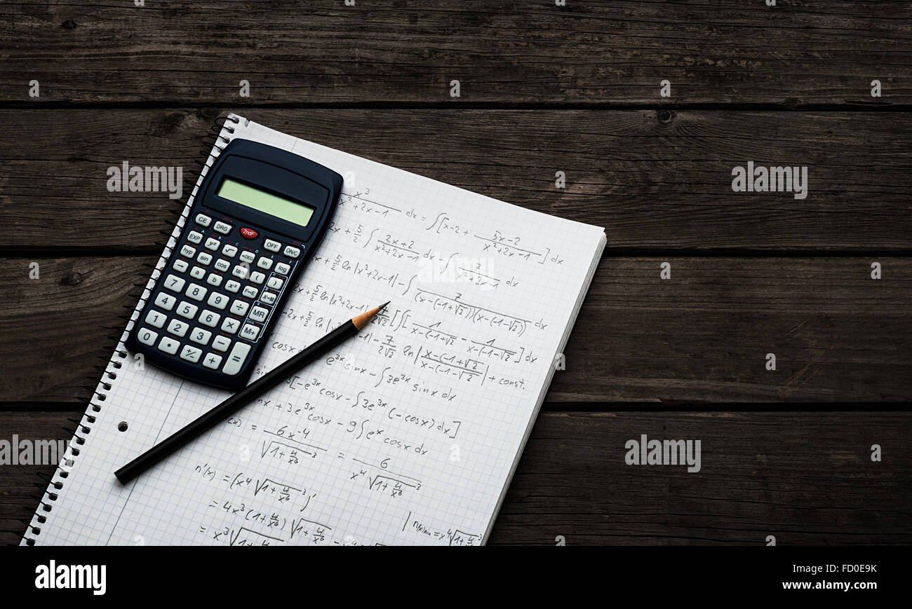 Mathematik-Konzept - Taschenrechner und Bleistift über ein Blatt Papier mit mathematischen Formeln Stockfoto