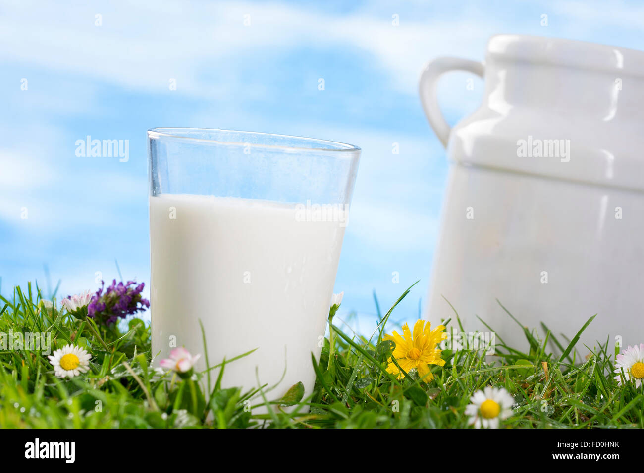 Glas Milch und Ug auf dem Rasen Stockfoto