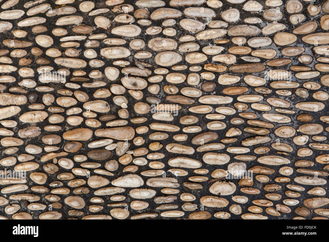 Kopfsteinpflaster gemacht von gerundet Flusskiesel in Córdoba, Andalusien, Spanien. Hintergrundtextur. Stockfoto