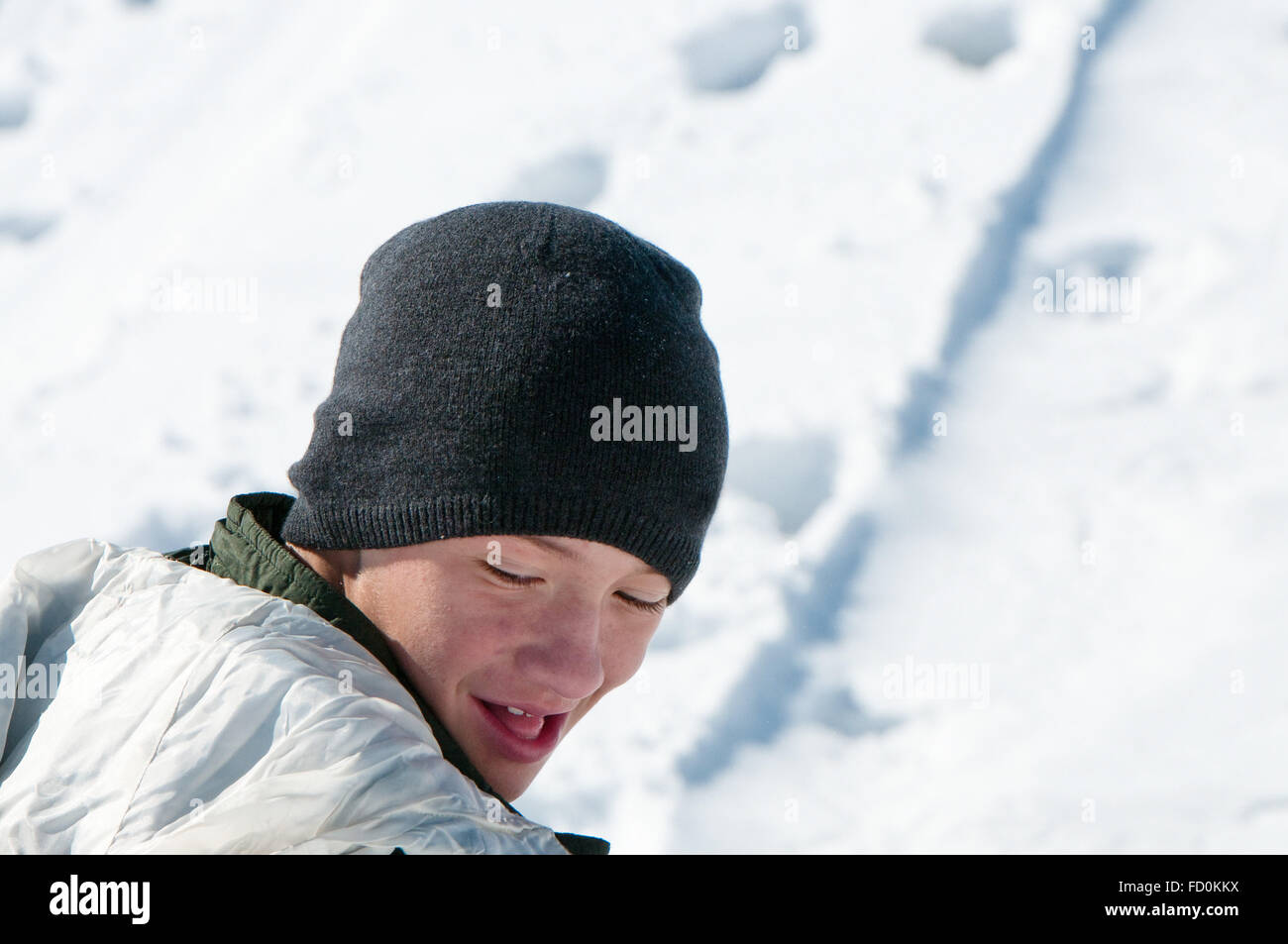 Nahaufnahme von einem jungen Teen Mann blickte und lächelnd in den Schnee Stockfoto
