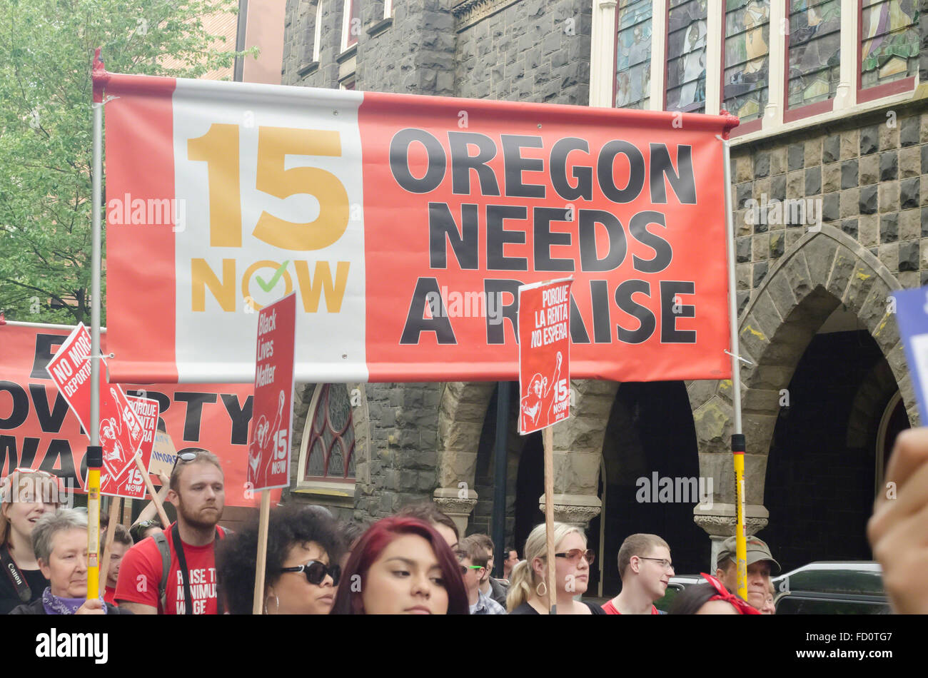 Demonstrator in 2015 Maifeiertag rally in Portland, Oregon halten einen Banner unterstützen eine landesweite Mindestlohn-Erhöhung Stockfoto