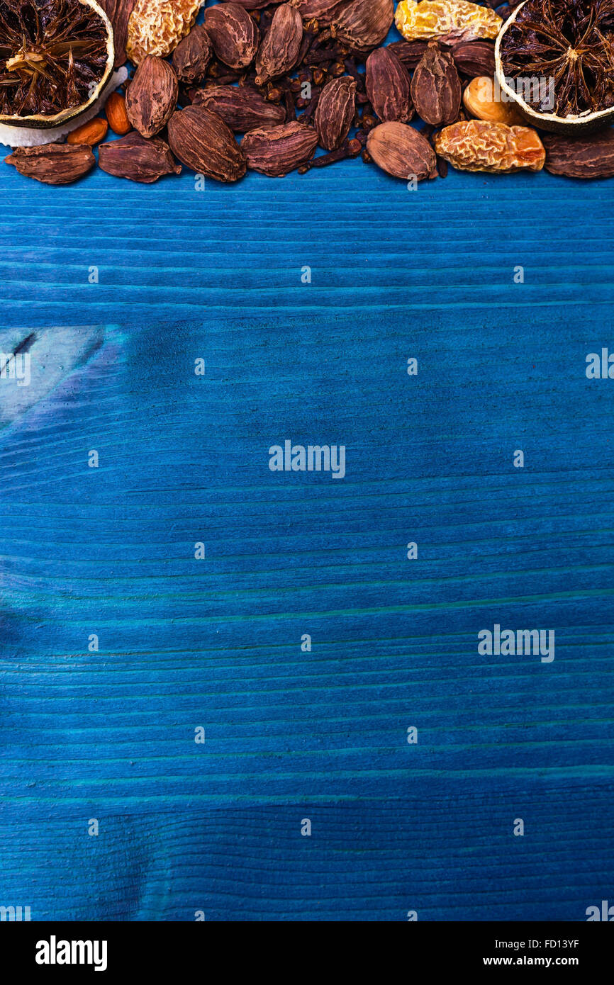 Verschiedene Gewürze: getrocknete Kalk, schwarzer Kardamom, Kokos und Nelke auf blauem Holz Schneidebrett Stockfoto