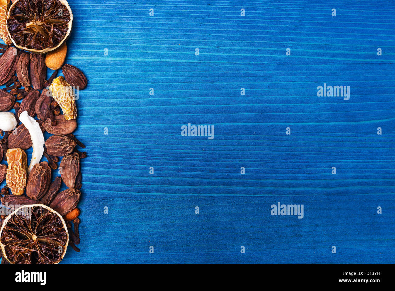 Verschiedene Gewürze: getrocknete Kalk, schwarzer Kardamom, Kokos und Nelke auf blauem Holz Schneidebrett Stockfoto