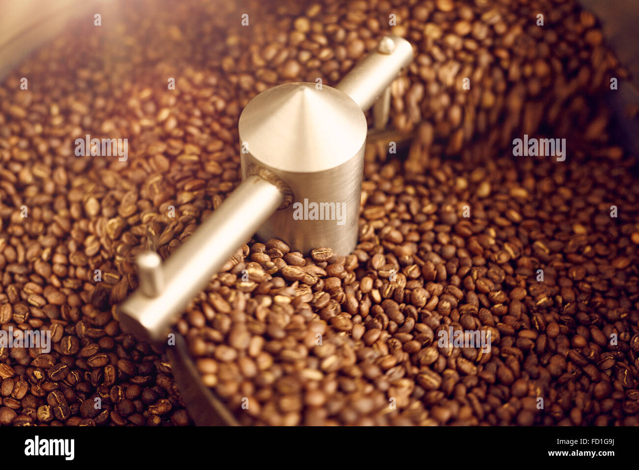 Aromatische Kaffeebohnen frisch geröstet in einem modernen Bräter machi Stockfoto