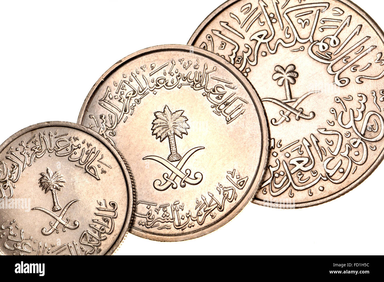 Münzen von Saudi Arabien zeigen östliche arabische Schrift und Ziffern, Palme und gekreuzte Schwerter Stockfoto