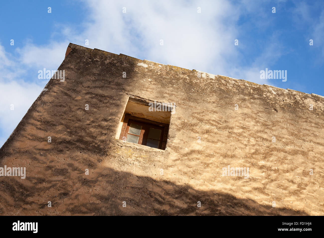 Kleines Fenster im alten Steinmauer unter blauen Wolkenhimmel Stockfoto Kleines Fenster im alten Steinmauer unter blauen Wolkenhimmel Stockfoto