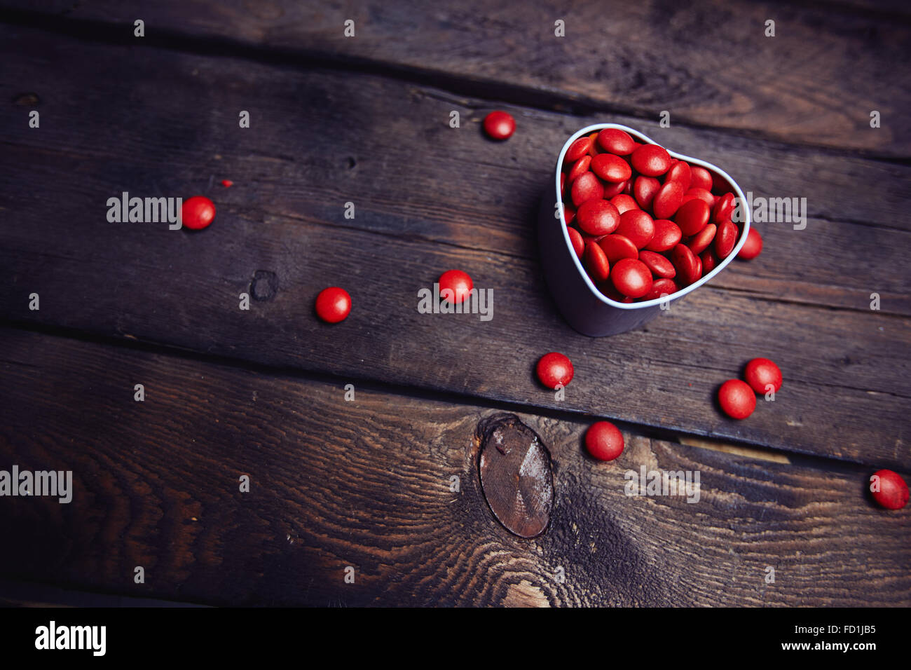 Rote Runde Bonbons in Herzform Box auf hölzernen Hintergrund Stockfoto