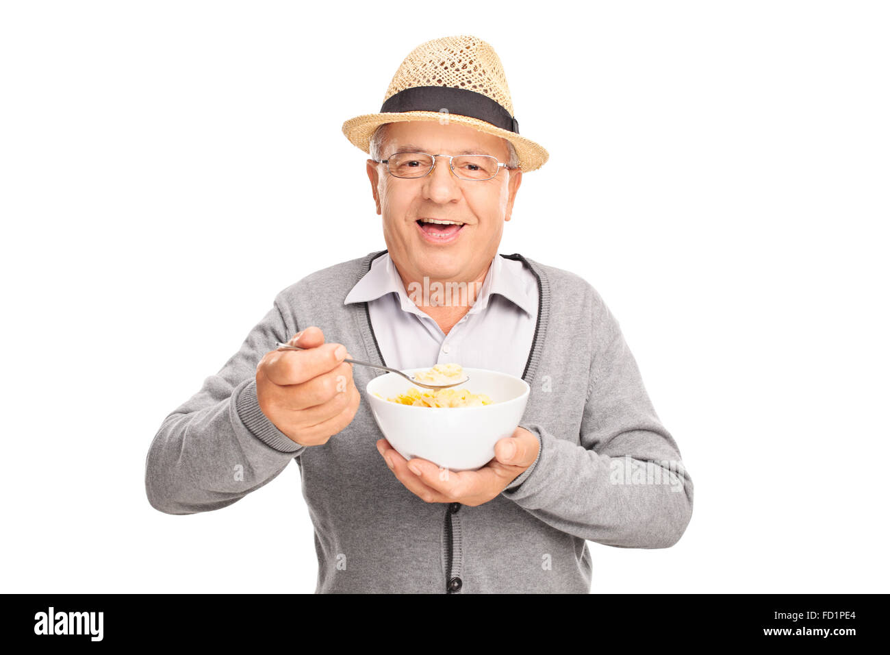 Studioaufnahme eines fröhlichen senior Gentleman essen Müsli aus einer Schüssel isoliert auf weißem Hintergrund Stockfoto
