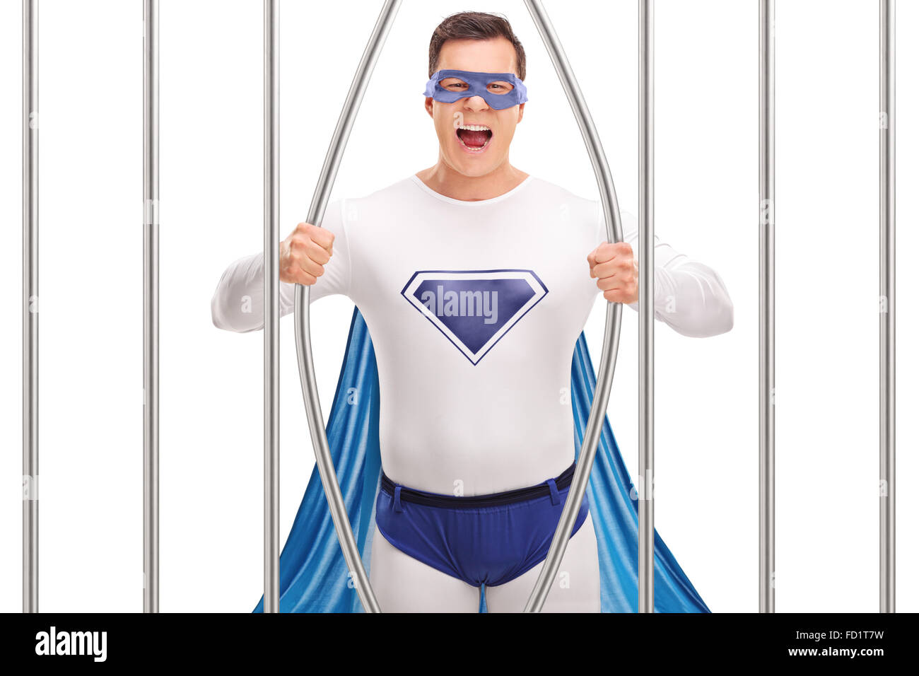 Junger Mann in Superhelden-Kostüm brechen aus dem Gefängnis durch Biegen die Balken auf weißem Hintergrund isoliert Stockfoto